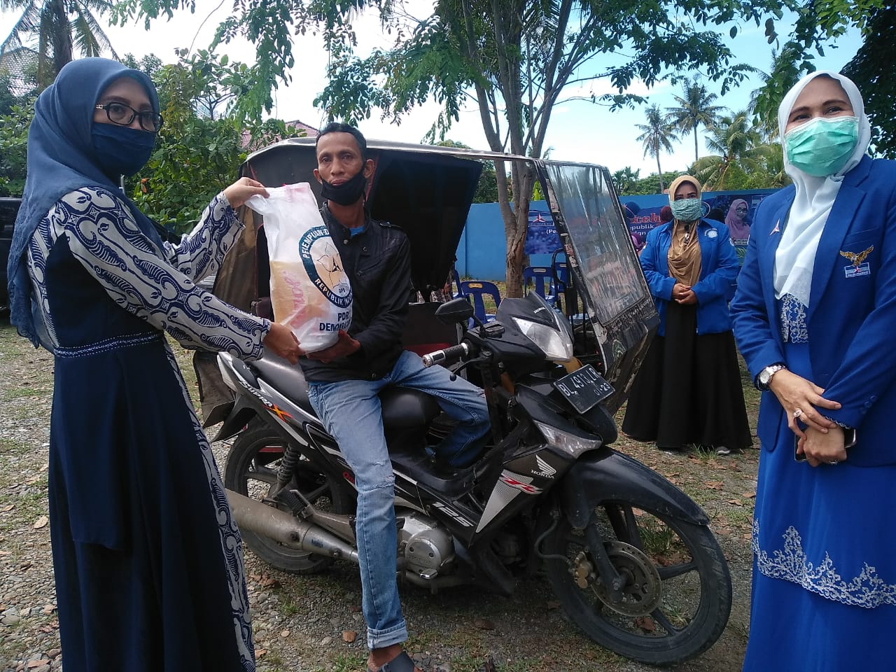 Pembina PDRI Provinsi Aceh Dr Dyah Erti Idawati didampingi Ketua PDRI Aceh Yusliana membagikan paket sembako kepada warga yang terdampak Covid -19 di Banda Aceh, Selasa (7/4/2020). [FOTO/ ISMAIL PHONNA]