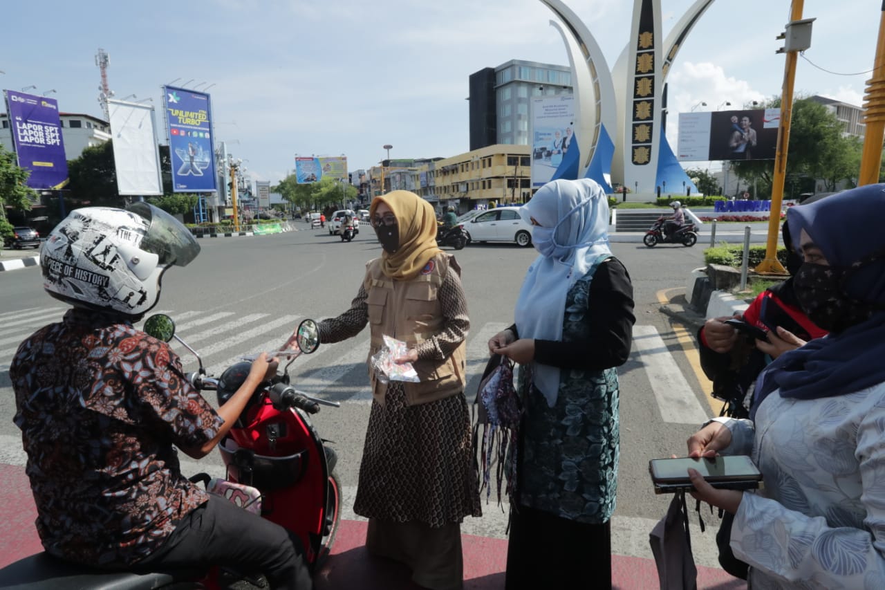 FOTO/ HUMAS DISDIK ACEH Wakil Ketua TP PKK Aceh, Dr Ir Dyah Erti Idawati MT membagi-bagikan masker gratis bersama para guru, dan siswa SMK 3 Banda Aceh kepada pengguna jalan di Bundaran Simpang Lima, Kamis (9/4/2020)