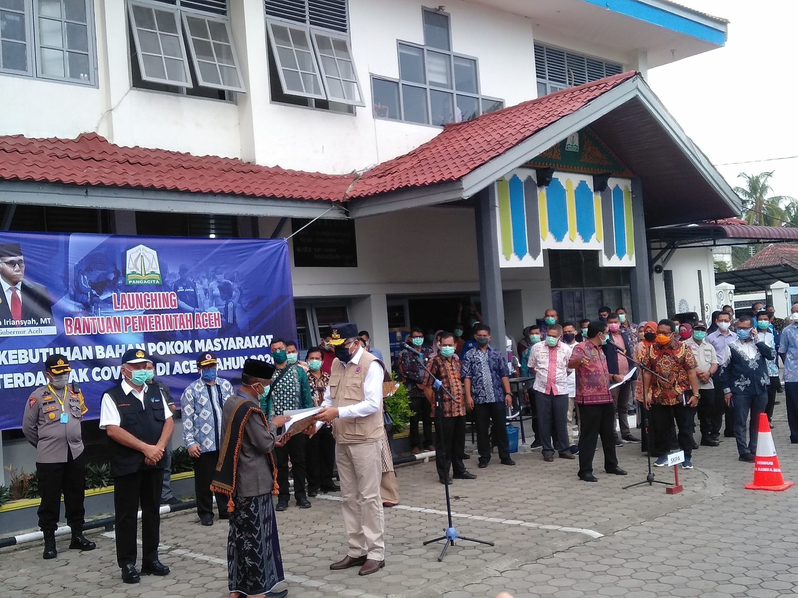 FOTO/ ISMAIL PHONNA Plt Gubernur Aceh Ir Nova Iriansyah MT menyerahkan paket sembako Pemerintah Aceh yang terima oleh Wakil Bupati Aceh Besar Tgk H Husaini A Wahab di Halaman Kantor Dinas Sosial Aceh, di Banda Aceh, Kamis (9/4/2020)