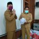SERAHKAN MASKER - Bupati Aceh Besar Ir H Mawardi Ali secara simbolis menyerahkan bantuan masker kepada Kadis Pangan Aceh Besar Ir Fuadi Akhmad di Aula Setdakab Aceh Besar, Senin (6/4/2020). FOTO/ HUMAS PEMKAB ACEH BESAR