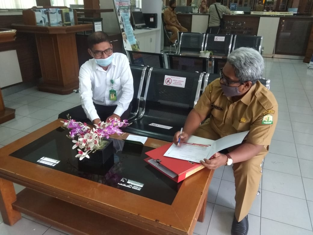 Staf Ahli Gubernur bidang perekonomian, keuangan dan pembangunan Dr Mahyuzar mSi, sedang melakukan kerjasama dengan karyawan Bank Aceh Syariah Capem Kantor Gubernur, Mulyadi, Senin (6/4/2020), dengan tetap menjaga jarak (FOTO/ TEUKU AZHARI)