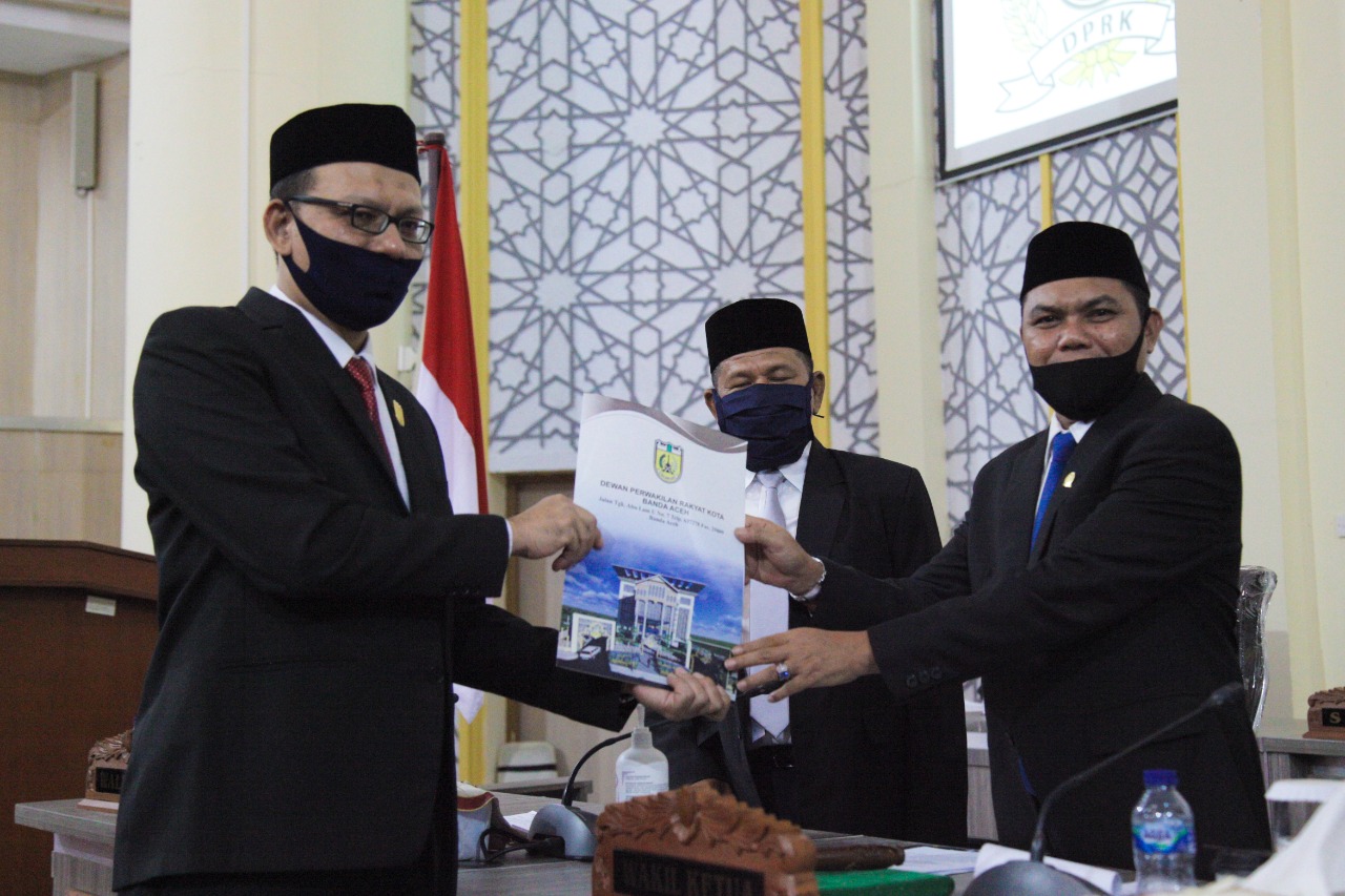 FOTO/ HUMAS DPRK BANDA ACEH Ketua Komisi I Musriadi SPd MPd menyerahkan rekomendasi dewan kepada pimpinan rapat paripurna penyampaian rekomendasi DPRK Banda Aceh terhadap LKPJ Wali Kota Banda Aceh Tahun 2019, H Isnani Husda SE di Gedung DPRK setempat, Jumat (29/5/2020).