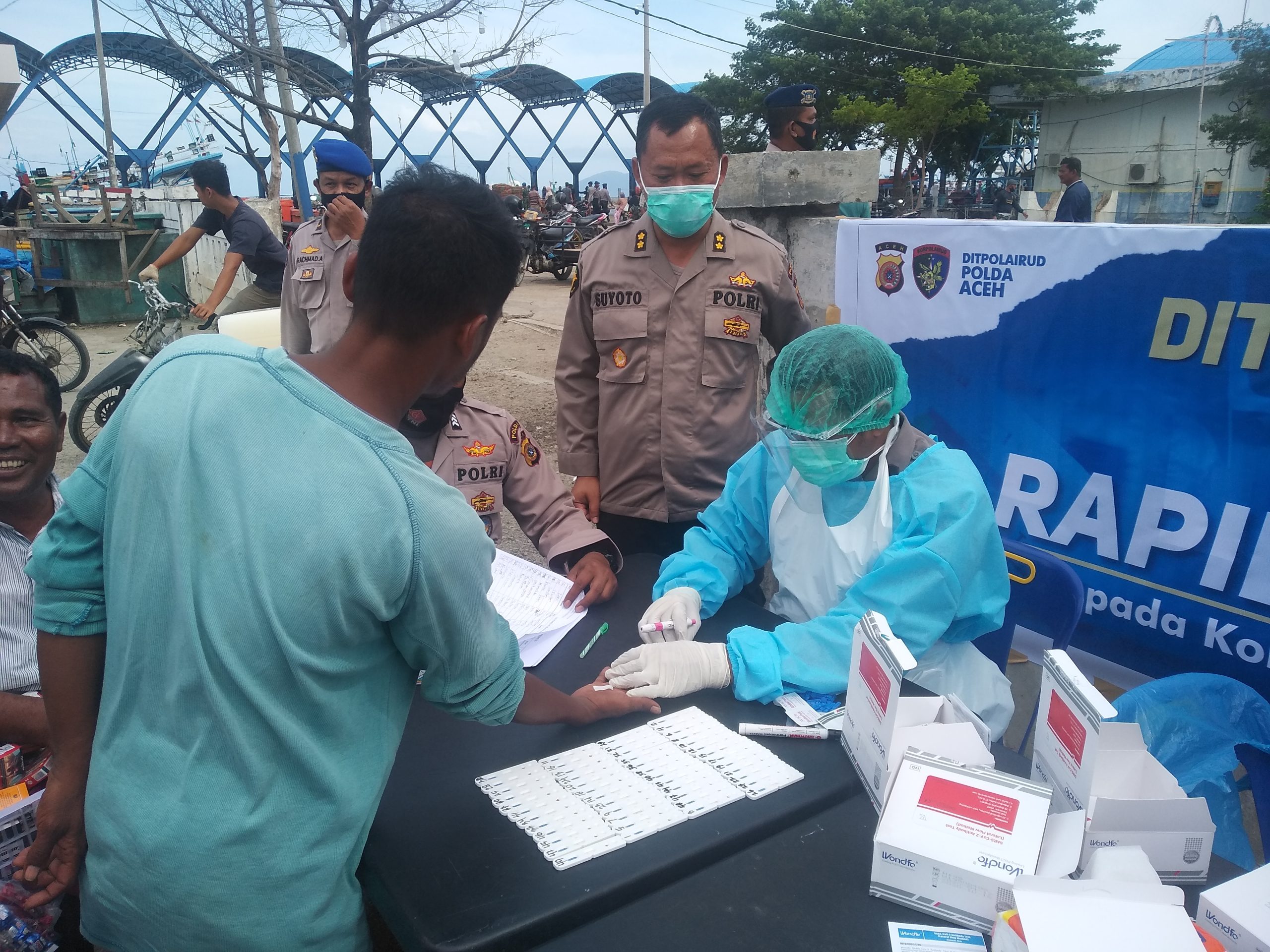 FOTO/ ISMAIL PHONNA Kasubdit Dokpol Biddokes Polda Aceh, AKBP Suyoto SKM menyaksikan pelaksanaan rapid test kepada para nelayan di TPI Lampulo, Banda Aceh, Senin (19/10/2020).