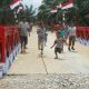 TNI AD berhasil menyelesaikan pembangunan Jembatan Modular di Dusun Bandar Baru, Desa Tanjung Genteng, Kecamatan Kejuruan Muda, Kabupaten Aceh Tamiang, Kamis (26/2/2026). Foto anak dan warga setempat melewati jembatan yang dibangun TNI AD. FOTO/ PENDAM IM