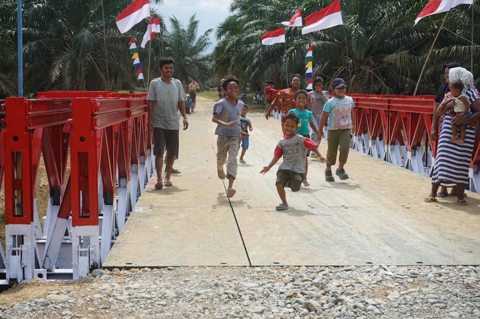 TNI AD berhasil menyelesaikan pembangunan Jembatan Modular di Dusun Bandar Baru, Desa Tanjung Genteng, Kecamatan Kejuruan Muda, Kabupaten Aceh Tamiang, Kamis (26/2/2026). Foto anak dan warga setempat melewati jembatan yang dibangun TNI AD. FOTO/ PENDAM IM